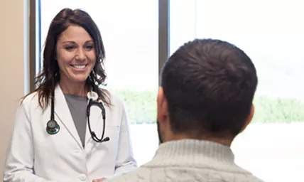 Female primary care doctor speaking with a male patient