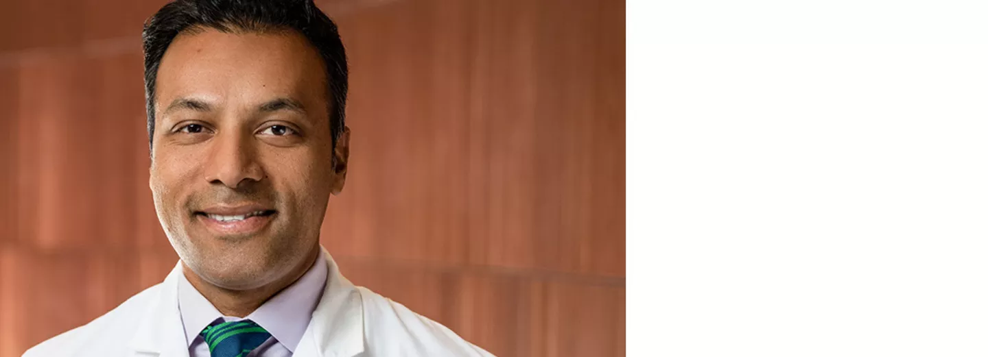 Ballad Health doctor smiling in front of wood background